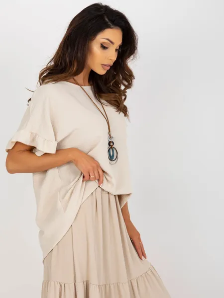 Light beige, airy oversize blouse with a necklace.