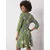 Women's green dress with plant patterns.